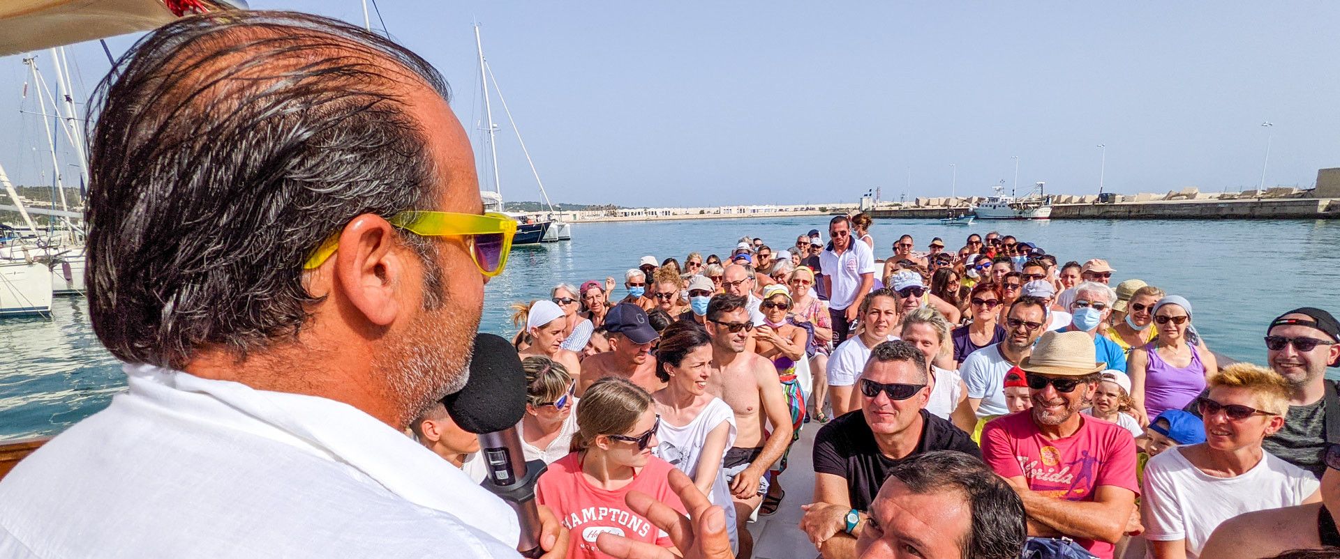 animatore mentre spiega l'itinerario a bordo della motobarca Leonarda al porto di Vieste